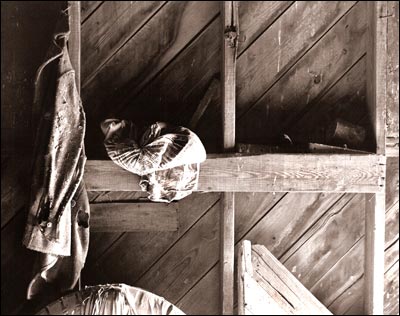 A coat, a tire, and a bag of seed were left in a barn long after their use. Photo copyright 2008 by Leon Unruh.