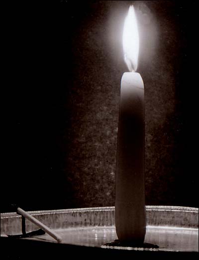 Lighted candle in a pie plate. Photo copyright 2010 by Leon Unruh.