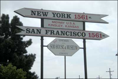 Sign in Kinsley, Kansas, stating it the distance from Kinsley is 1,561 miles to New York City and San Francisco. Photo copyright 2010 by Leon Unruh.