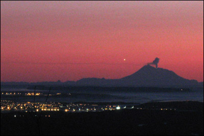 Redoubt volcano sends up ash and steam on March 15, 2009. Viewed from Eagle River, Alaska. Photo copyright 2009 by Leon Unruh.